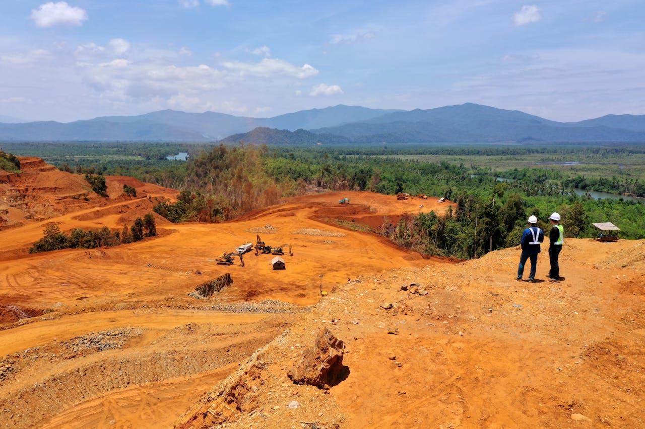 hero-img-02 Expansive view of a mining area in Molawe, Sulawesi, with workers and machinery.